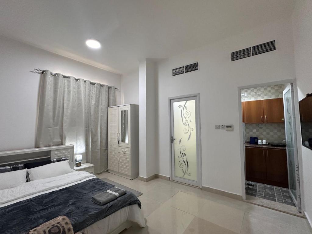 a bedroom with a bed and a sliding door at Cozy Studio Retreat in Al Ain in Al Ain