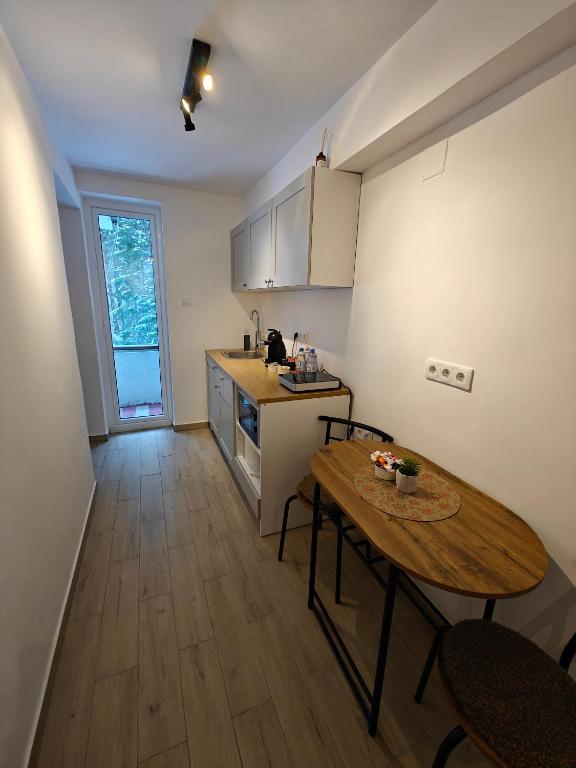 a kitchen with a wooden table and a table and chairs at Red Lake Apartman in Lacu Rosu