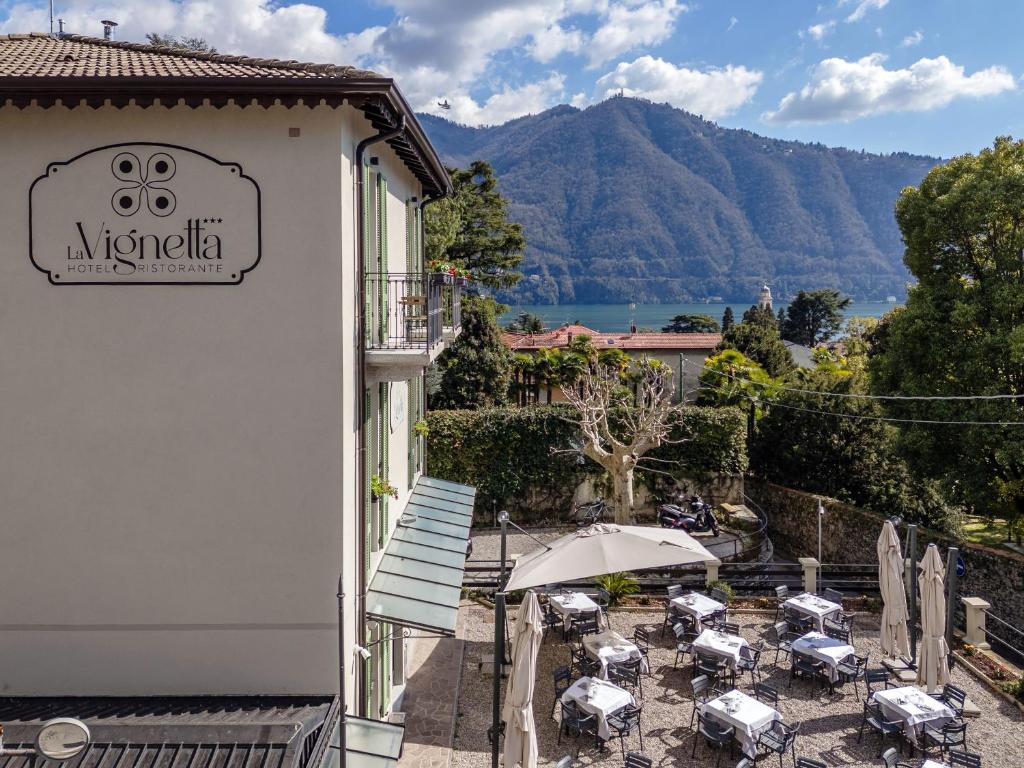 a balcony with tables and an umbrella in front of a building at Hotel Ristorante La Vignetta Cernobbio in Cernobbio