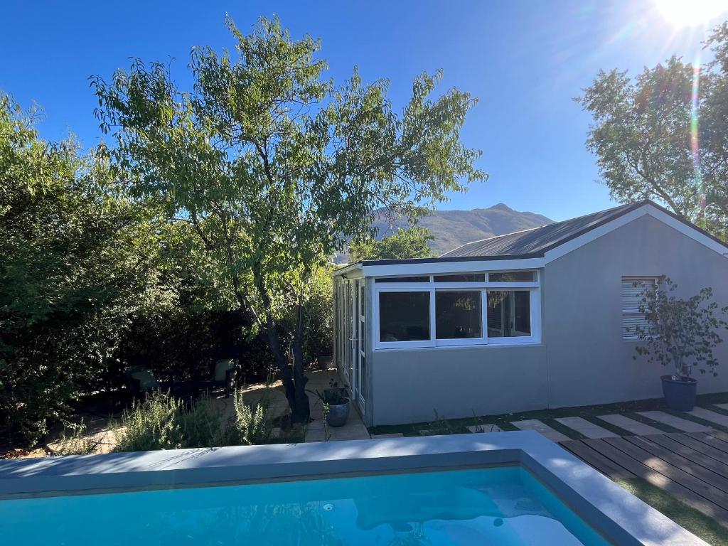 a house with a swimming pool in the yard at Almond Cottage in Riebeek-Kasteel