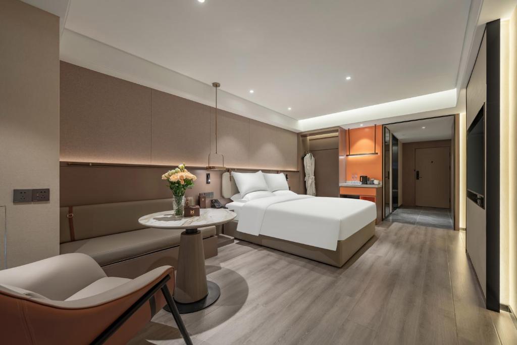 a hotel room with a bed and a table at 沃德酒店济南经十东路融创文旅城店 in Jinan