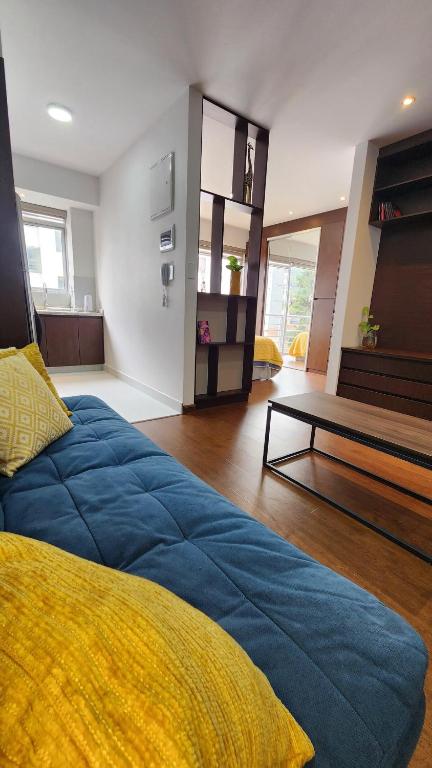a living room with a blue bed and a table at The Urban Echo in Cochabamba