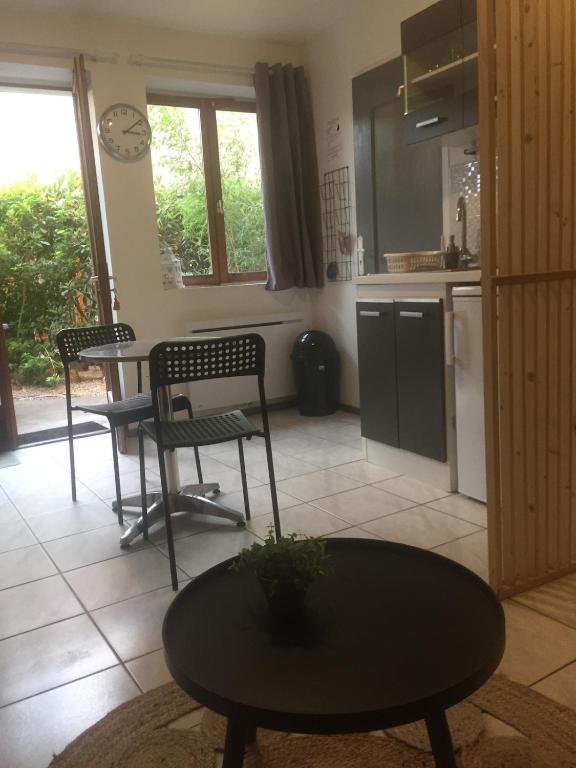 un salon avec une table et des chaises et une cuisine dans l'établissement LES GITES CHEROIS agréable RDC maison- 2 personnes, à Les Chères