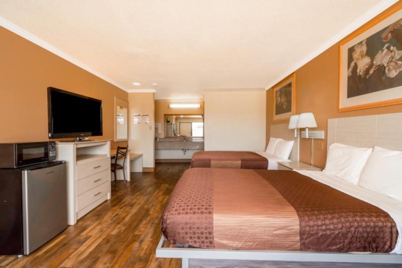 una camera d'albergo con due letti e una TV a schermo piatto di River Valley Motor Inn a La Grange