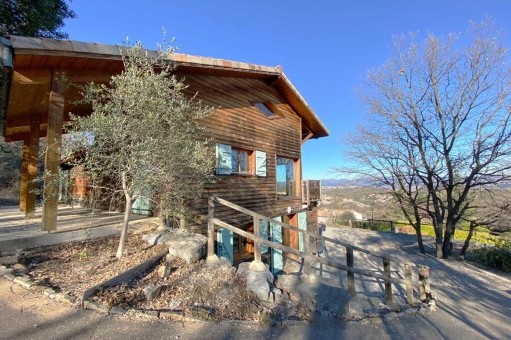 une maison en rondins avec une clôture devant elle dans l'établissement L'escapade Ardéchoise, à Ailhon