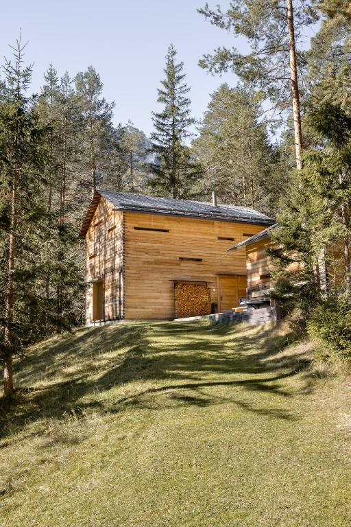 a log cabin in the woods with a yard at Mountain Lodge Tamersc in San Vigilio Di Marebbe