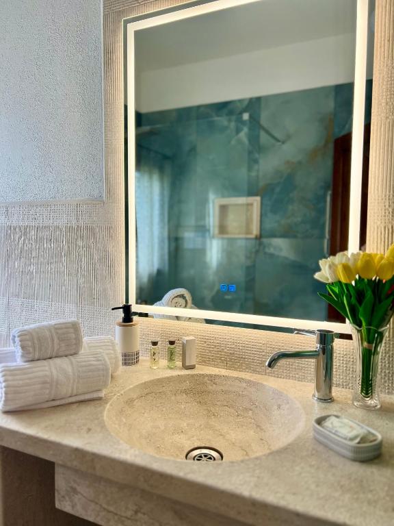 a bathroom sink with a large mirror above it at Villa Scirocco in Cala Liberotto