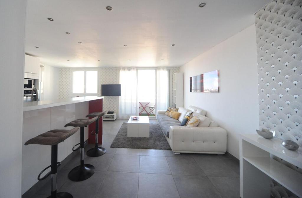 un salon blanc avec un canapé et une table dans l'établissement Cosy appartement - Longchamp - vue Mer !, à Marseille
