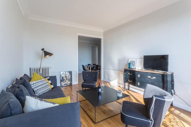 a living room with a couch and chairs and a table at GuestReady - Designer Apartment - Eiffel Tower View! in Paris