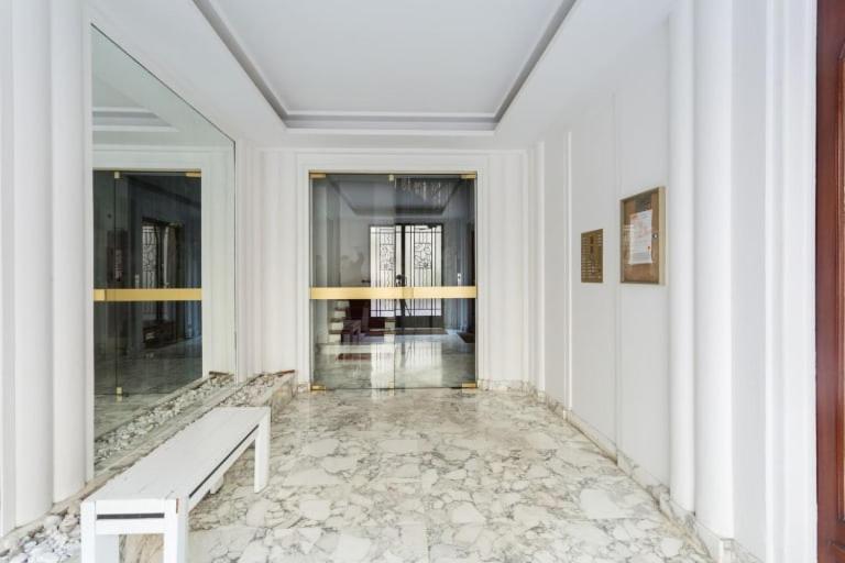 a white hallway with a bench in a building at GuestReady - Designer Apartment - Eiffel Tower View! in Paris