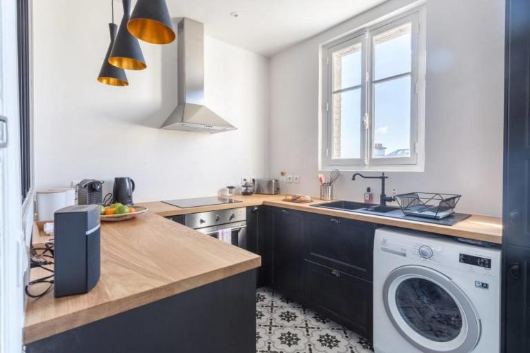 a kitchen with a washing machine and a sink at GuestReady - Designer Apartment - Eiffel Tower View! in Paris