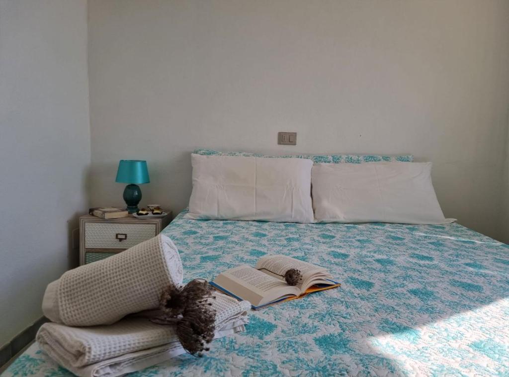 a bedroom with a bed with a book on it at Villa Smeraldo - Appartamento Fronte Mare a Capo Rizzuto in Capo Rizzuto