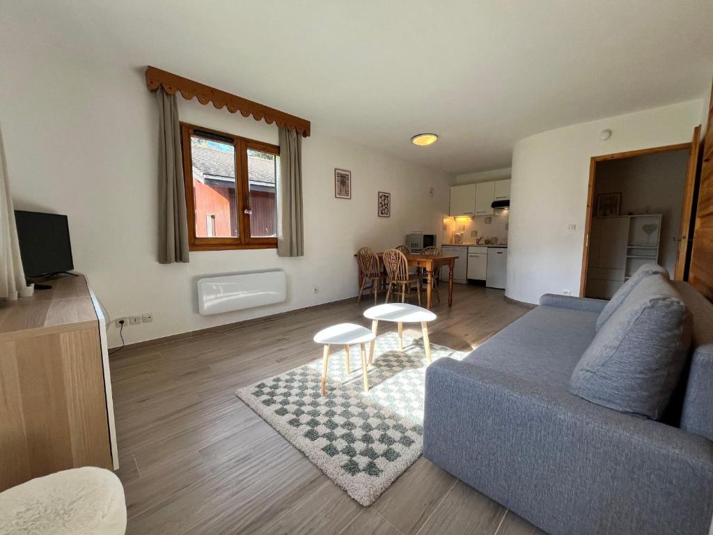 un salon avec un canapé bleu et une table dans l'établissement Appartement lumineux avec piscines, terrasse et parking à Samoëns - FR-1-624-125, à Samoëns