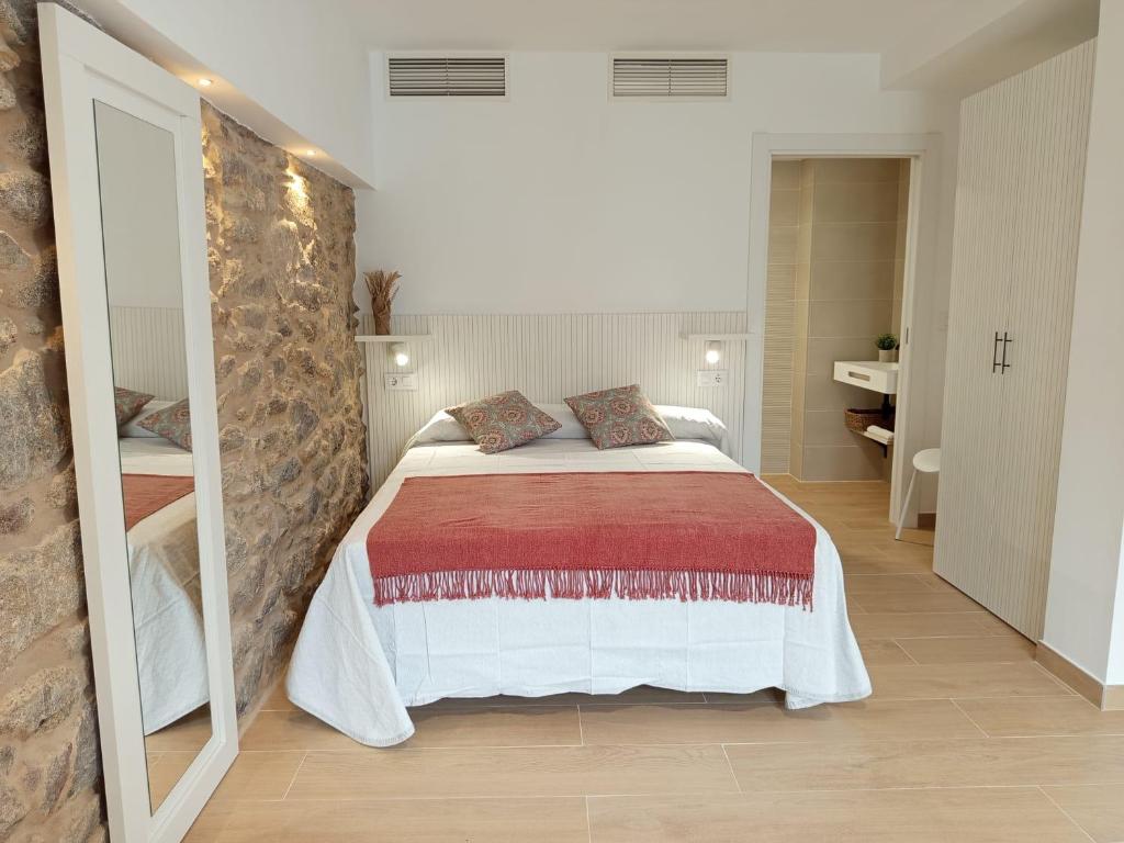 una camera da letto con un letto e un grande specchio di Vaiche Boa! a Corcubión