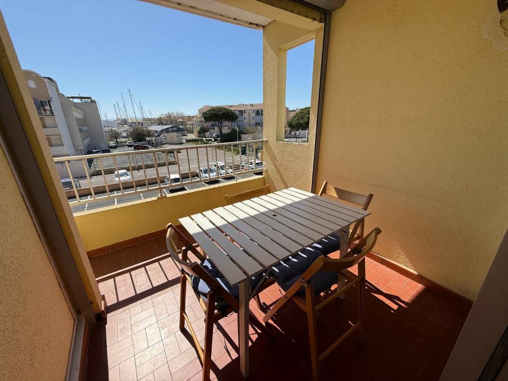 une table et des chaises sur un balcon avec vue dans l'établissement Studio Cabine à Gruissan pour 4 Pers. avec Loggia et Parking Privé – Résidence Voile d'Oc - FR-1-784-11, à Gruissan