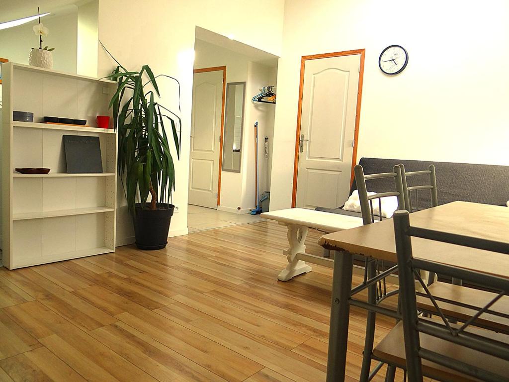 - un salon avec une table et une horloge murale dans l'établissement Appartement sous les combles, à Rezé
