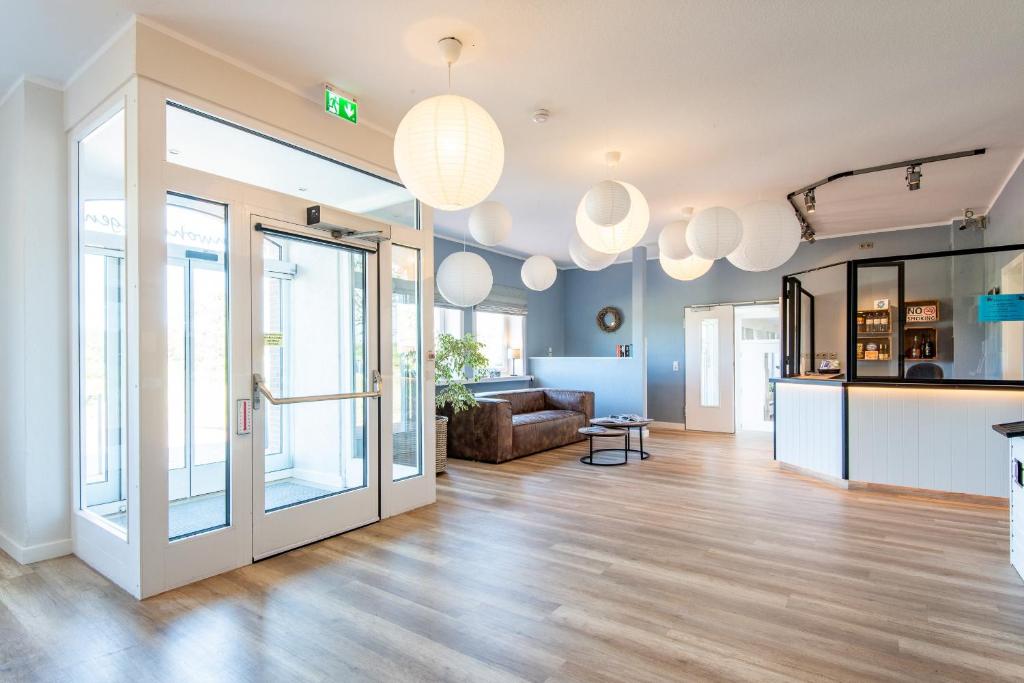 an open living room with a couch and glass doors at Steger-Hüs Wohnung 41 in Rantum