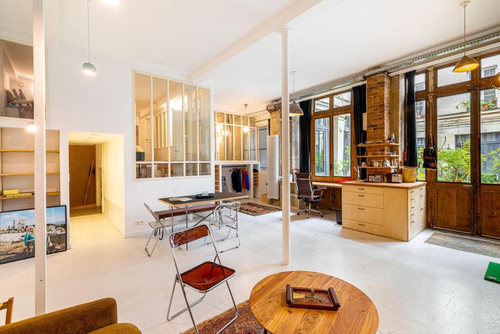 un salon avec une table et une cuisine dans l'établissement GuestReady - Midcentury Maisonette in the 10th, à Paris