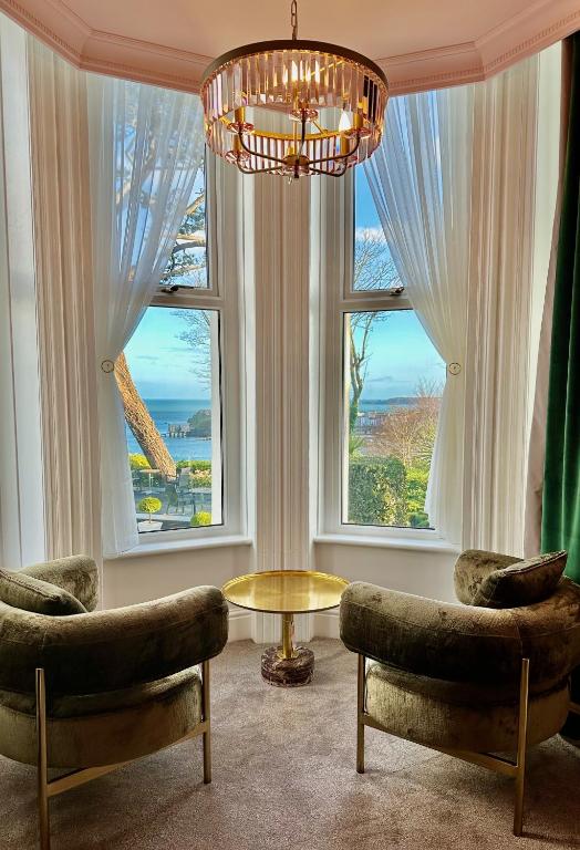 a living room with two chairs and a chandelier at The Park Hotel in Tenby