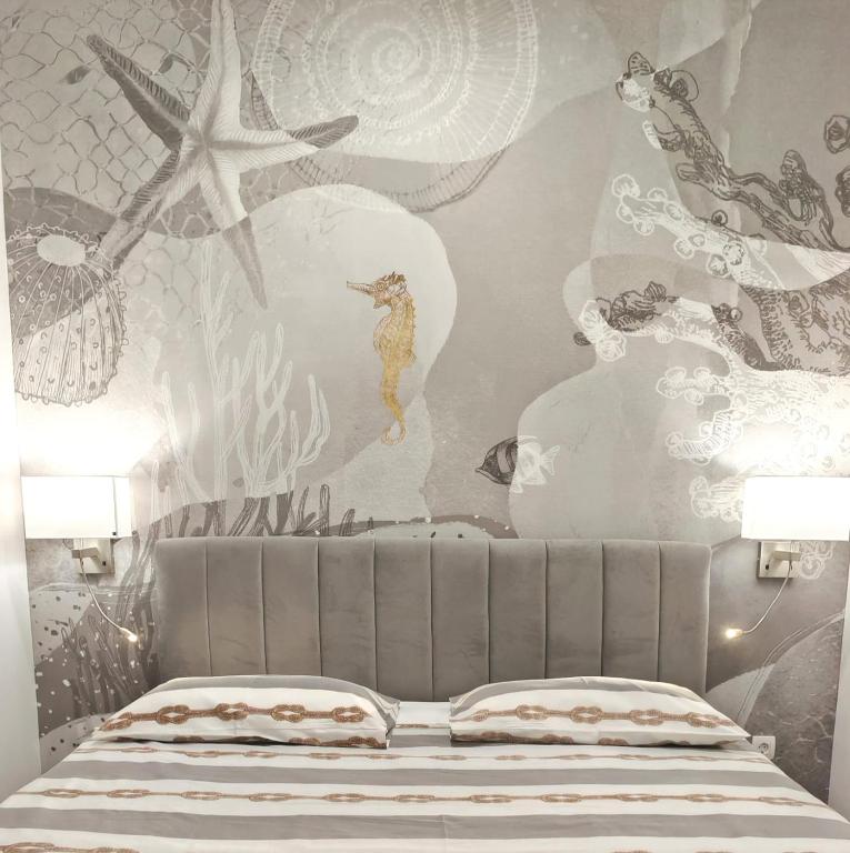 sypialnia z łóżkiem i ścianą z obrazem w obiekcie Apartments & Rooms Kolovare Beach 3, Zadar w mieście Zadar