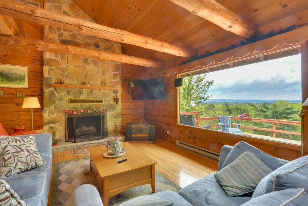 Cabaña con sala de estar con chimenea de piedra. en Peaceful Bedford Escape Deck and Stunning Views!, en Bedford