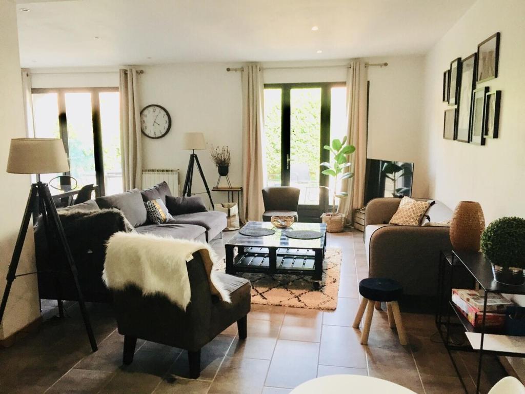 un soggiorno con un divano e un tavolo di LES GITES CHEROIS sweet home maison 8 personnes a Les Chères