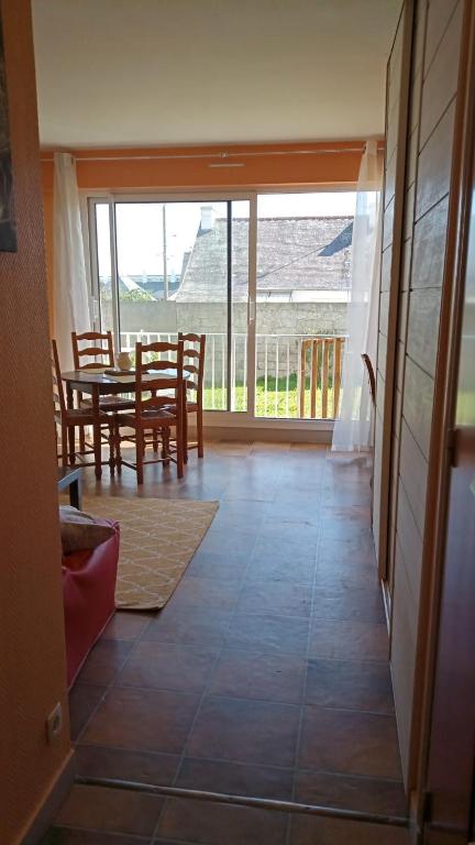 une salle à manger avec une table et des chaises et un balcon dans l'établissement Studio à 100 m de la plage, à Audierne