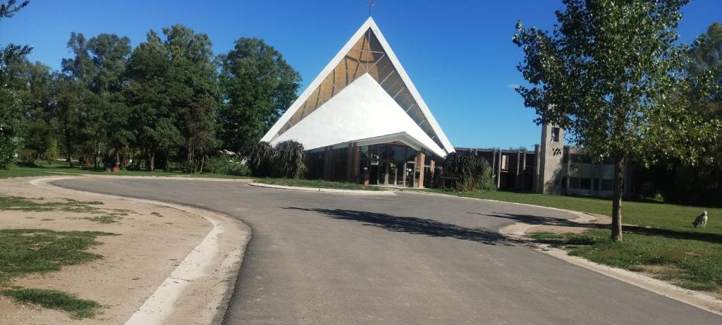 a building with a pointed roof on the side of a road at Cabañas Don Pocho in Villa Cura Brochero