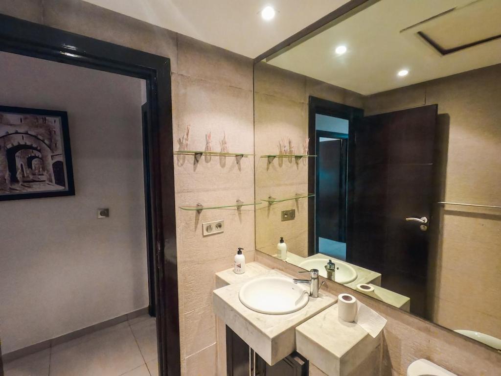 un baño con lavabo y espejo en Luxury and Comfort-Chic Apartment, en Agadir