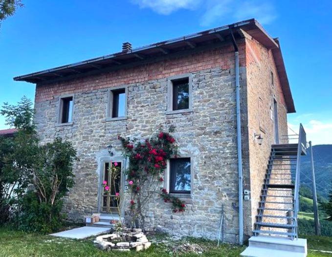 a brick house with flowers on the side of it at Bosco Stellato in Casteldelci