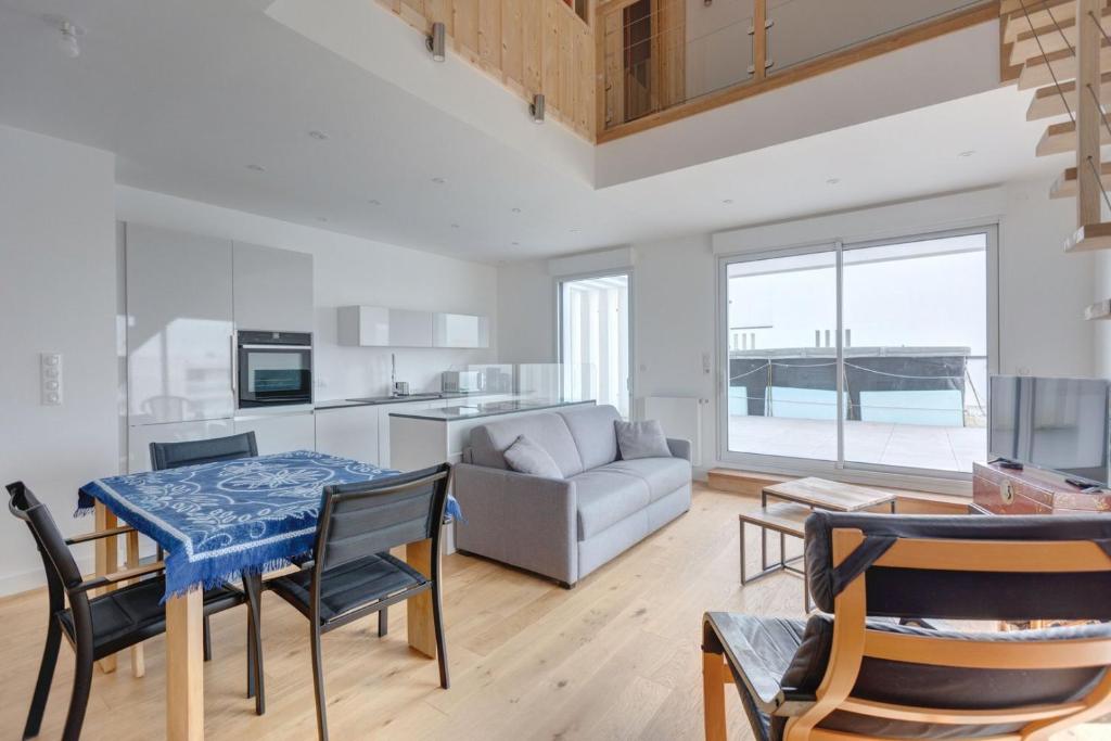 une cuisine et un salon avec une table et des chaises dans l'établissement GuestReady - 2 BR with Terrace near Bordeaux, à Le Bouscat