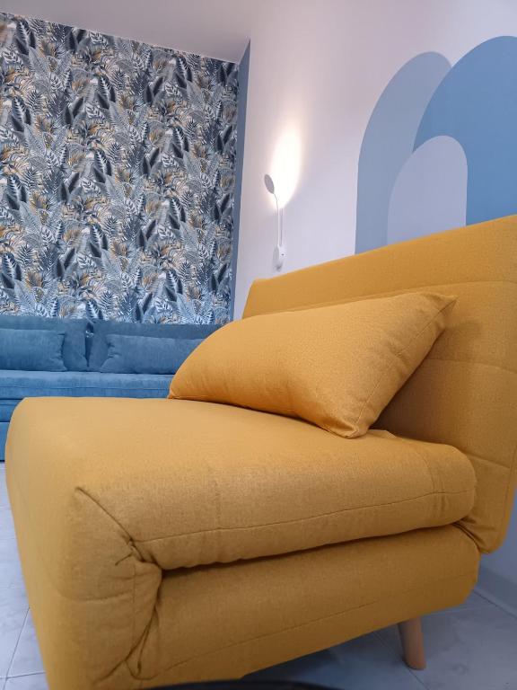a yellow couch in a living room with a window at Artistika on the beach in Bibione