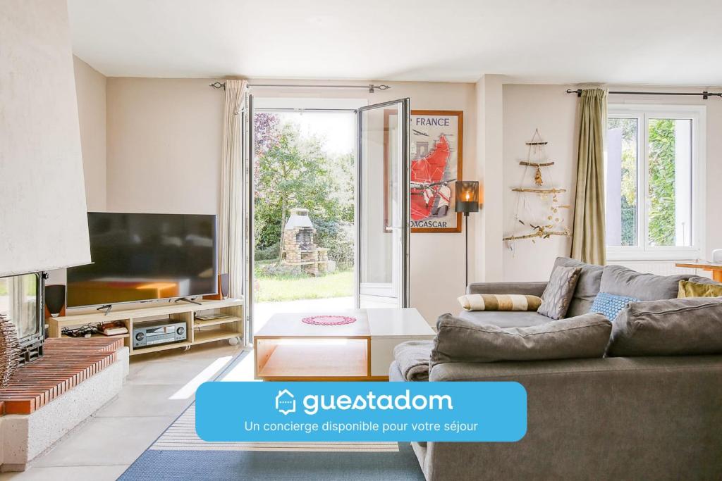 un salon avec un canapé et une télévision dans l'établissement L'Atoll Wifi Jardin Parking, à Beaucouzé