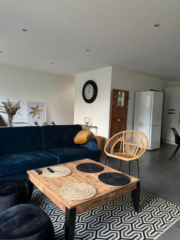 un salon avec un canapé bleu et une table basse dans l'établissement Les gîtes cherois esprit moderne 8 personnes, à Les Chères