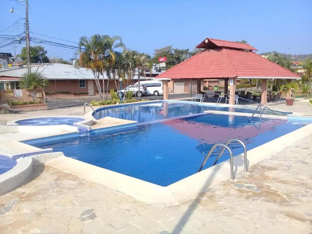 a large swimming pool with a gazebo at Villa Coco - Jaco Beach in Jacó