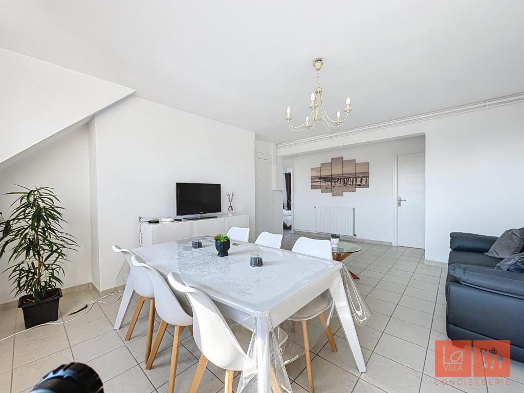 un salon avec une table et des chaises blanches dans l'établissement Le Ferber, à Wimereux