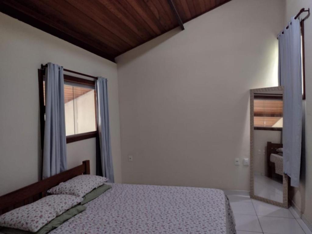 Toledo Damasco House في إيتاكاري: غرفة نوم بها سرير ومرآة ونافذة