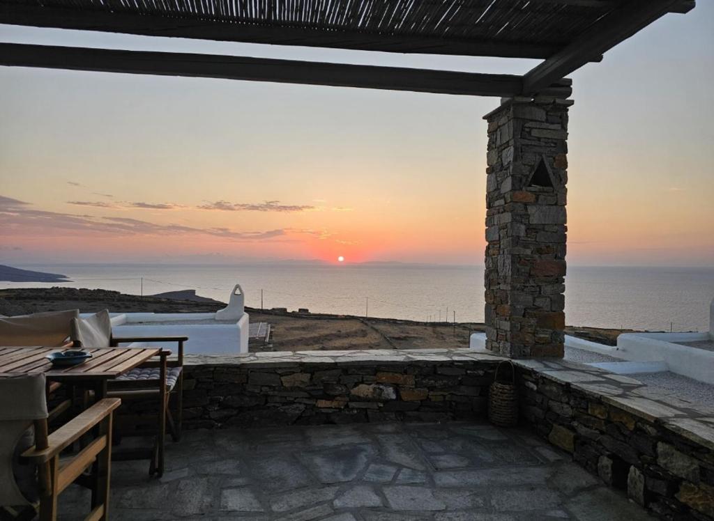 a patio with a view of the ocean at sunset at Aeraki in Kithnos