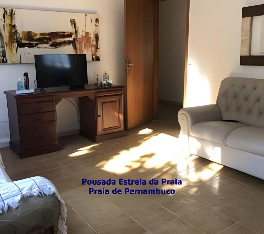 a living room with a television and a couch at Pousada Estrela da Praia - Aluguel Casa in Guarujá