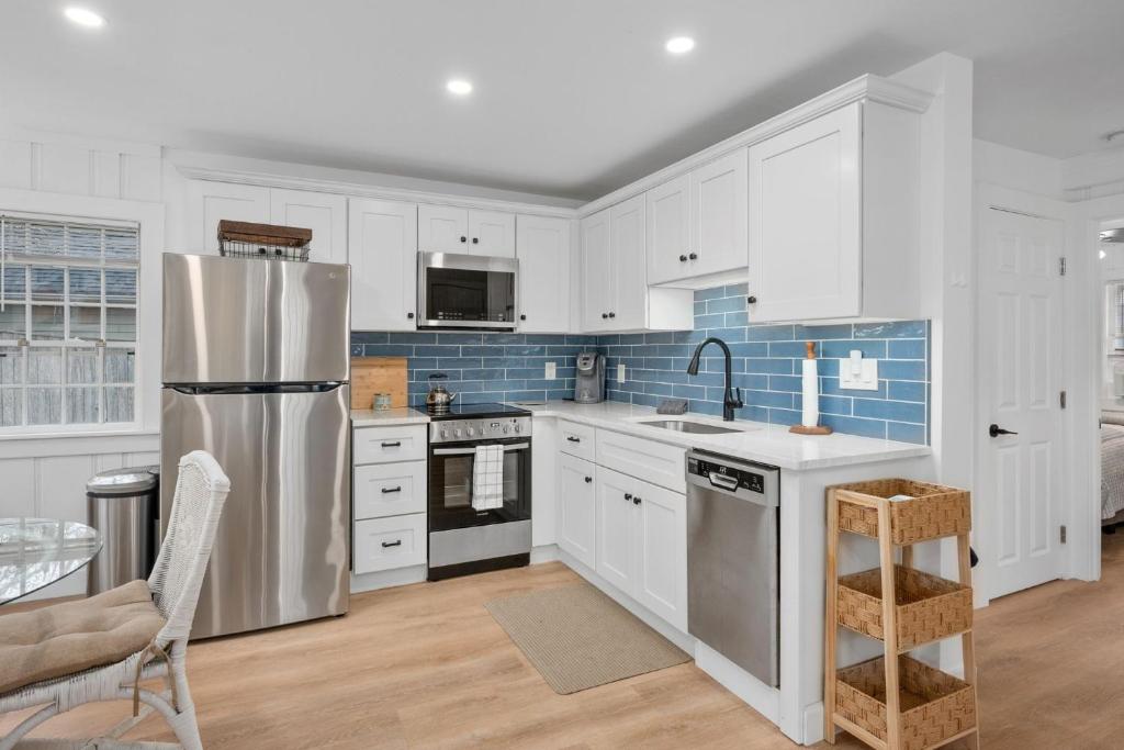 een keuken met witte kasten en een roestvrijstalen koelkast bij 9 Gilbert Street South Yarmouth- No Plans in South Yarmouth