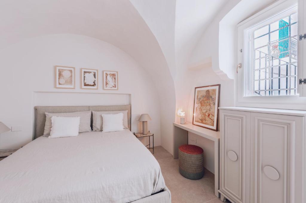 Un dormitorio blanco con una cama y una ventana. en Casa Annabella - Palazzo Venneri Lloyd, en Gallipoli