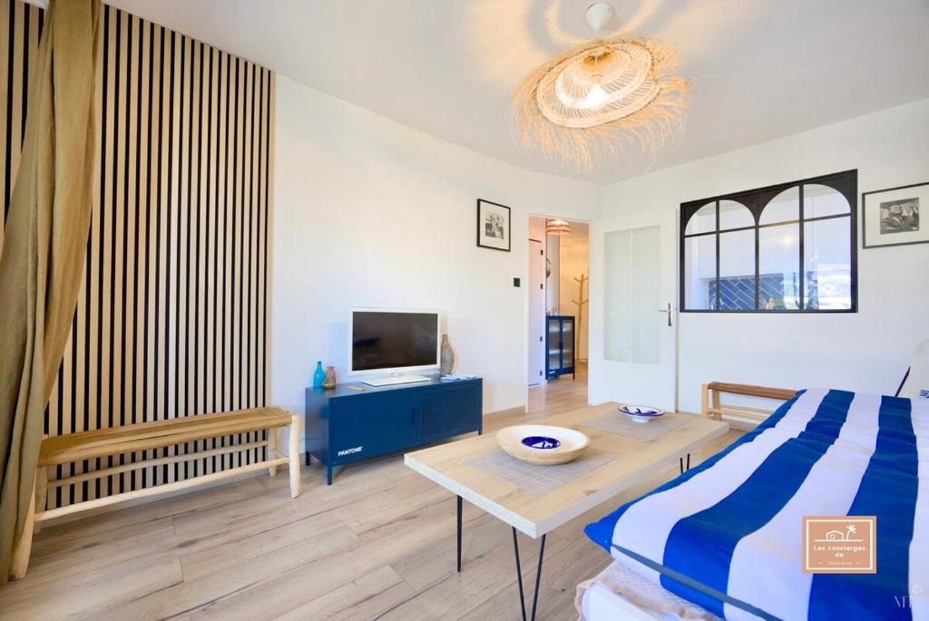 une chambre avec un lit, une table et une télévision dans l'établissement La Mandriote, plage à pied et clim, à Saint-Mandrier-sur-Mer