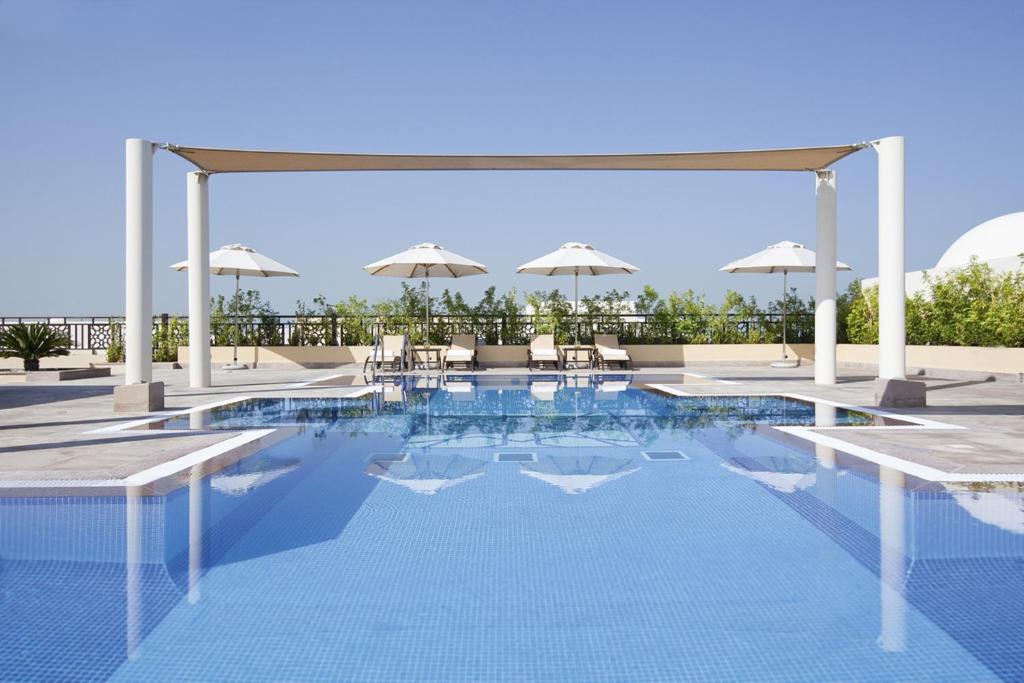 Бассейн в Mövenpick Hotel Apartments Al Mamzar Dubai или поблизости