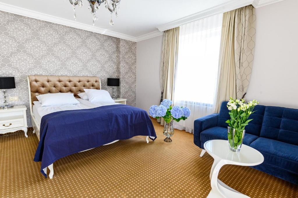 a bedroom with a blue bed and a blue couch at Moris Boutique Beach Hotel in Gdańsk