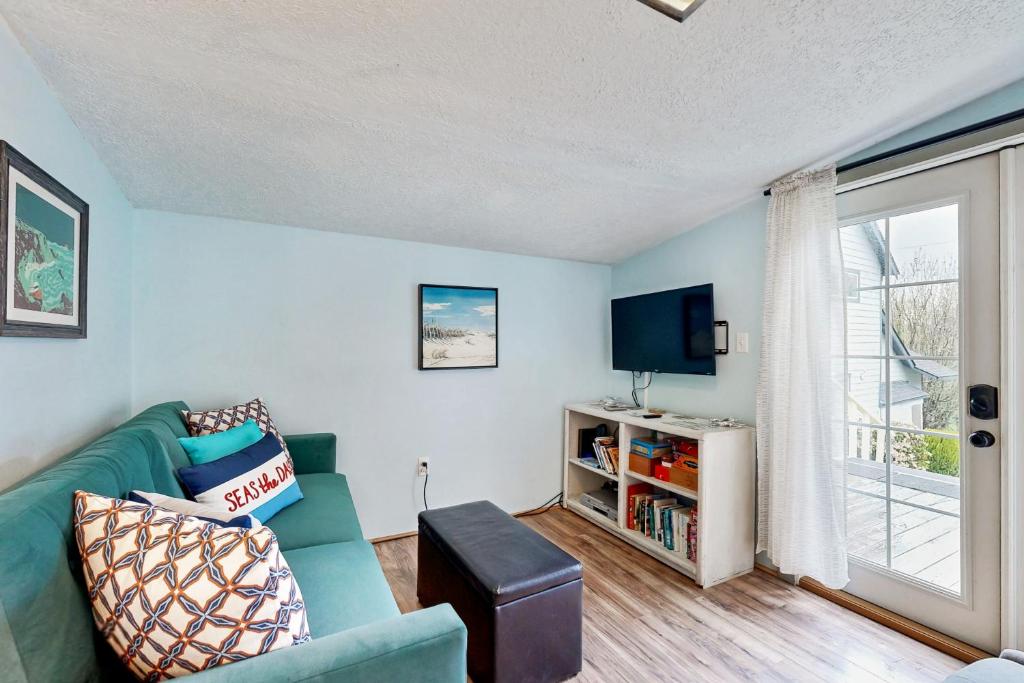 a living room with a couch and a tv at Happy Crabby Shack in Rockaway Beach