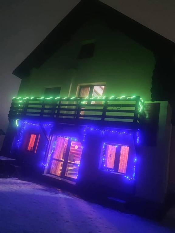 a house with blue and green lights on it at Cabana Alexander in Braşov