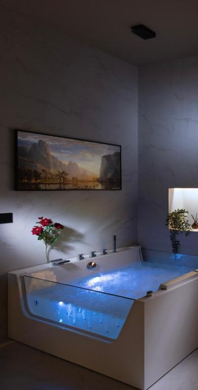a bathroom with a tub with a painting on the wall at CM Luxury Apartment in Catania