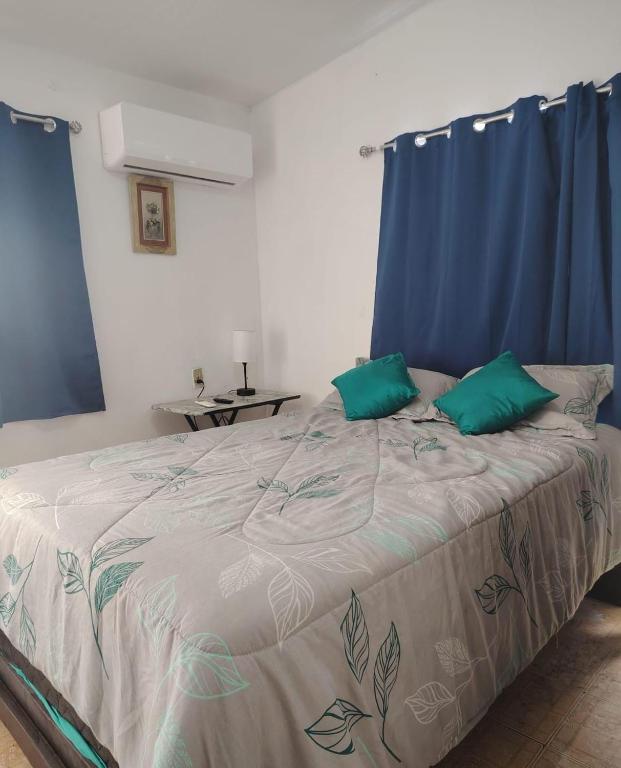 a bedroom with a large bed with green pillows at Departamento 2 a 200 mts de Imss 25 in Monterrey