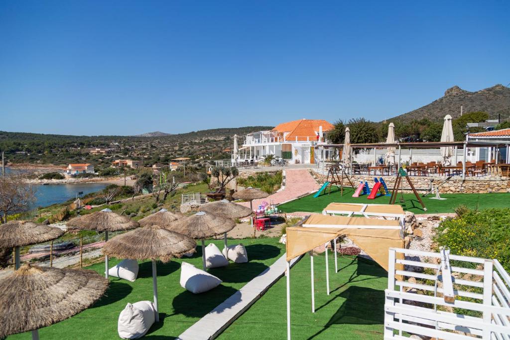 a view of a resort with chairs and umbrellas at Poseidon Apartments and Villas by the Sea in Sounio