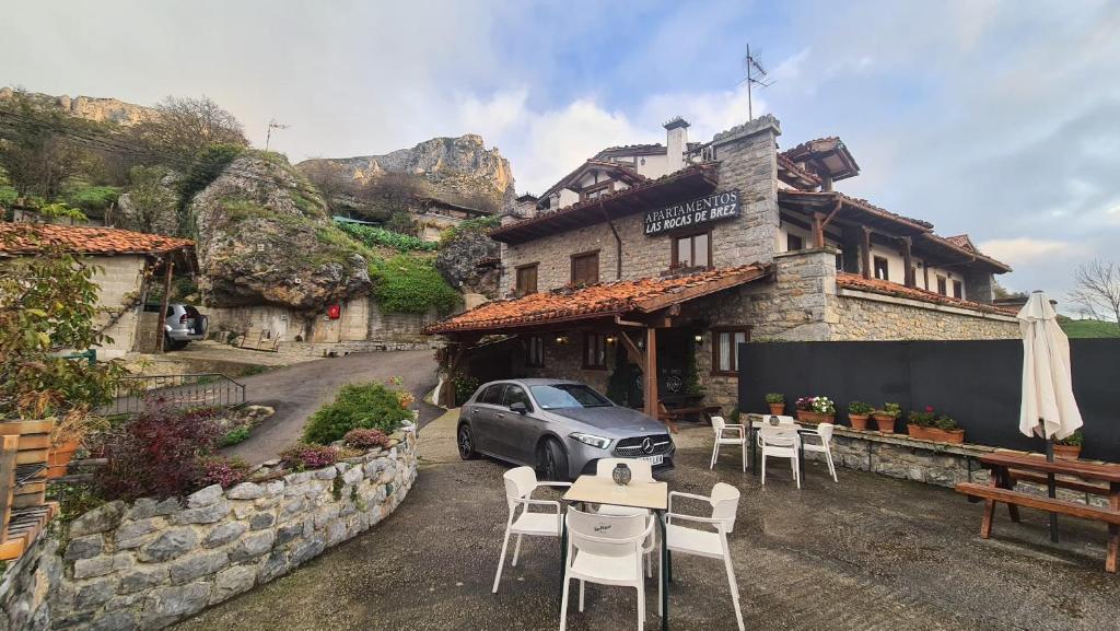 BrezにあるApartamentos Las Rocas de Brezのテーブルと椅子が備わる建物の前に駐車